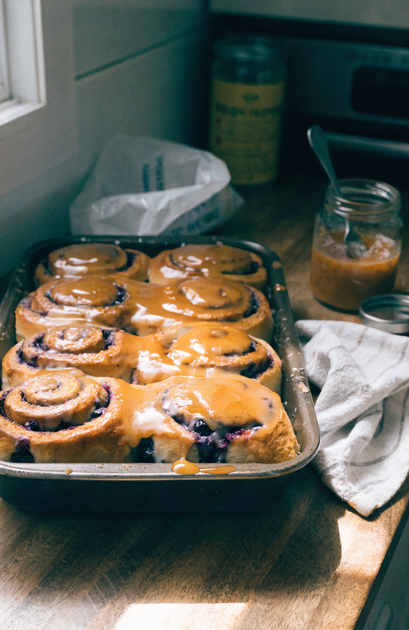 Blueberry cinnamon rolls with swirled filling and glaze on a 9x13 pan